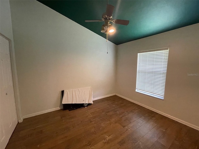 empty room with vaulted ceiling, ceiling fan, and dark hardwood / wood-style flooring