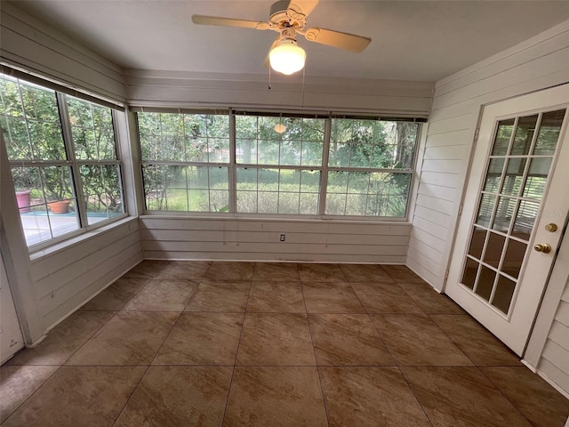 unfurnished sunroom with ceiling fan