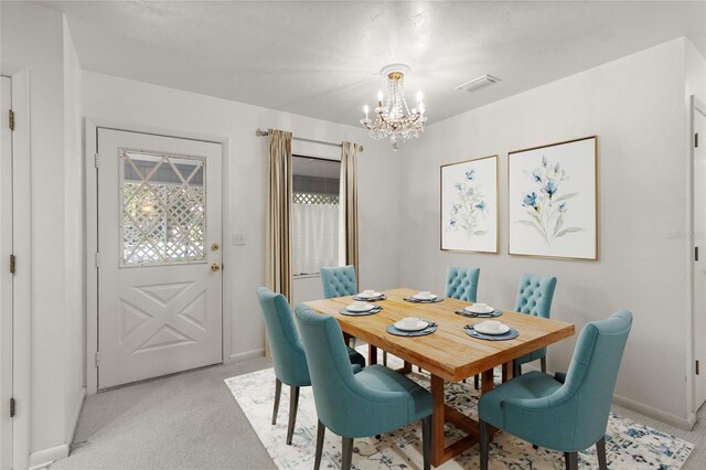 dining space featuring an inviting chandelier and light colored carpet