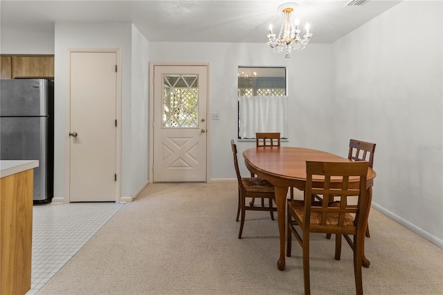 carpeted dining space featuring an inviting chandelier