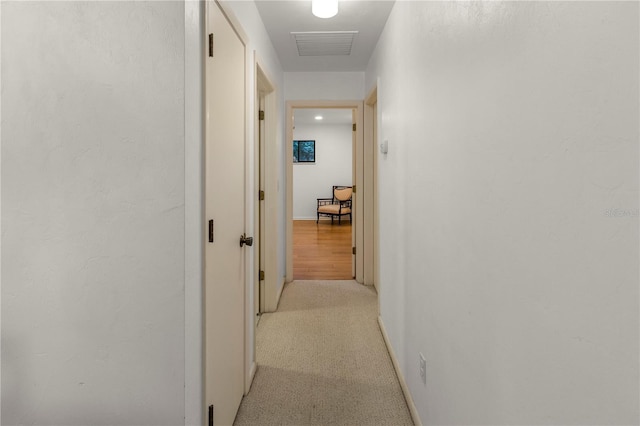 hall featuring light colored carpet