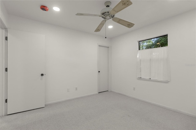 carpeted spare room with ceiling fan