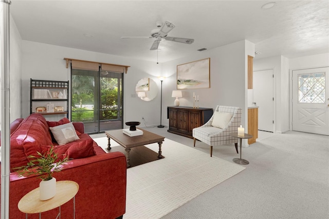 living room with plenty of natural light, light colored carpet, and ceiling fan