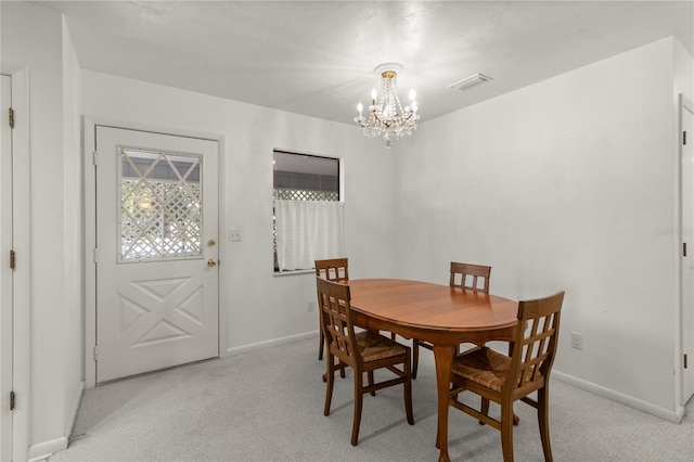 carpeted dining area with an inviting chandelier