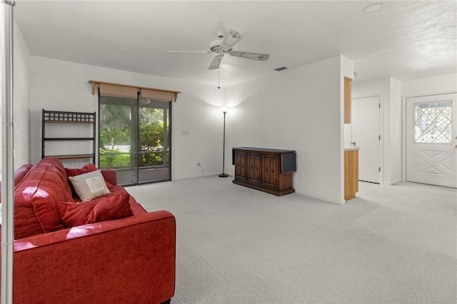 living room with ceiling fan, light colored carpet, and a healthy amount of sunlight