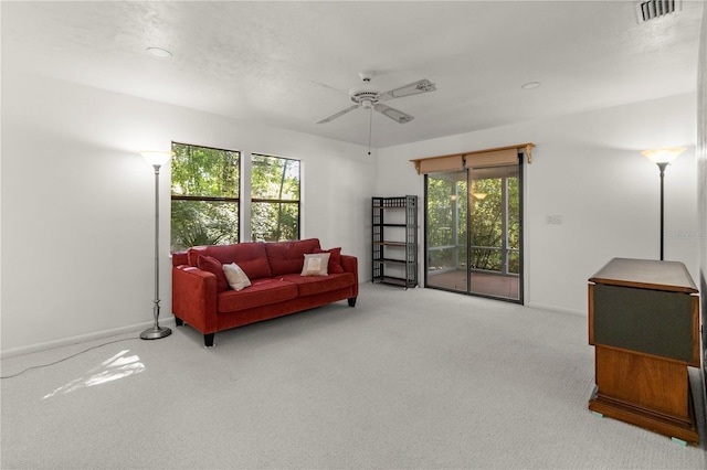 carpeted living room with ceiling fan and a healthy amount of sunlight