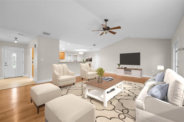 living room featuring ceiling fan, light wood-type flooring, and lofted ceiling