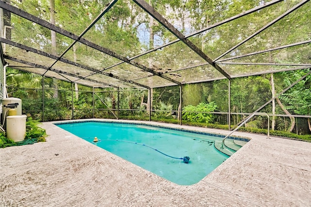 view of pool featuring glass enclosure and a patio