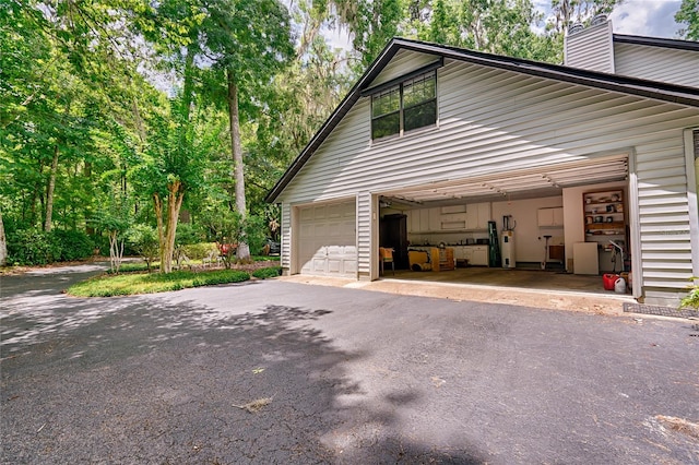 view of property exterior with water heater and a garage