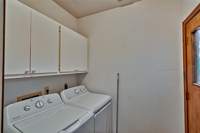 washroom featuring separate washer and dryer and cabinets