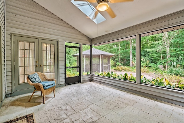 unfurnished sunroom with ceiling fan and vaulted ceiling with skylight