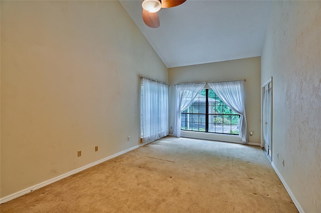 unfurnished room featuring light carpet, high vaulted ceiling, and ceiling fan