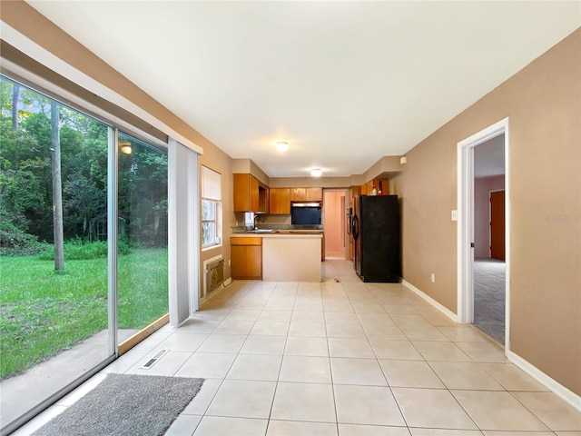 kitchen featuring black refrigerator and light tile patterned flooring