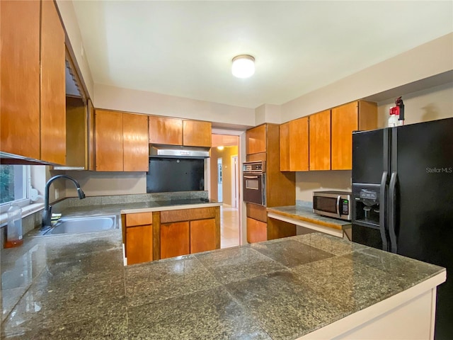 kitchen with sink, kitchen peninsula, and black appliances