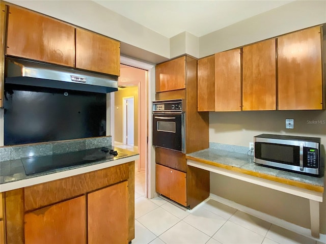 kitchen with black appliances and light tile patterned floors