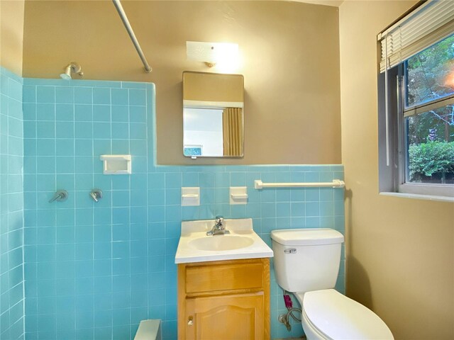 bathroom featuring tile walls, backsplash, vanity, and toilet