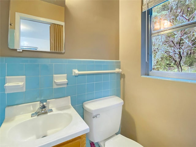 bathroom with toilet, tasteful backsplash, plenty of natural light, and vanity