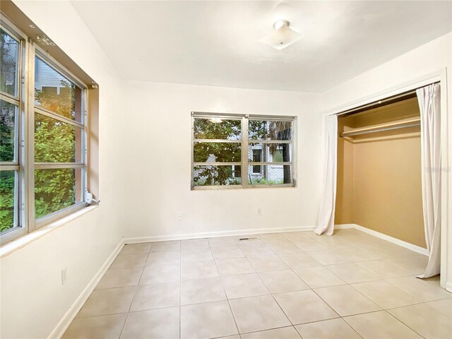 unfurnished bedroom featuring a closet and light tile patterned floors