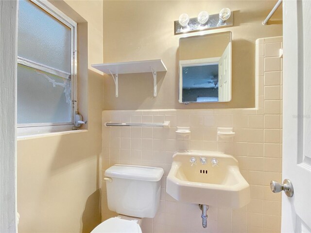 bathroom with tile walls, sink, and toilet