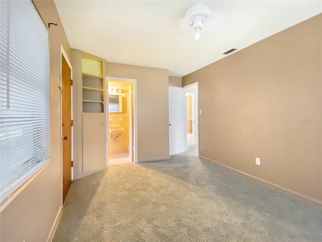 unfurnished bedroom featuring carpet flooring, a closet, and ensuite bathroom