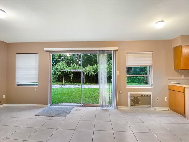 entryway with light tile patterned flooring and an AC wall unit