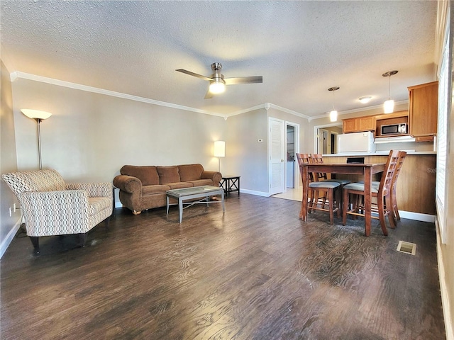 living room with a textured ceiling, dark hardwood / wood-style floors, ceiling fan, and crown molding