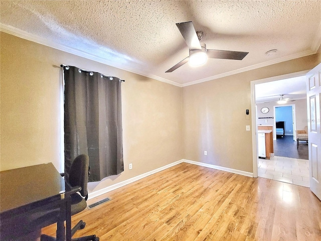 unfurnished office with ceiling fan, ornamental molding, a textured ceiling, and light wood-type flooring