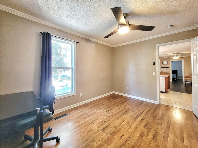 unfurnished office with light hardwood / wood-style flooring, a healthy amount of sunlight, and crown molding