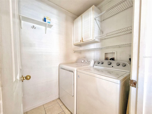 laundry area with cabinets, independent washer and dryer, light tile patterned floors, and ornamental molding