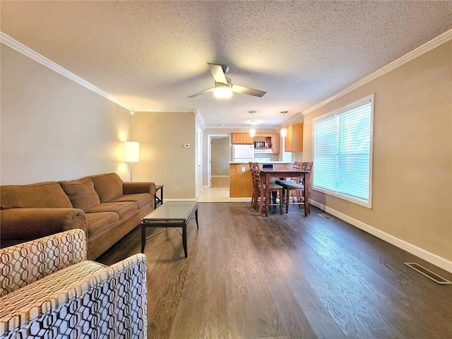 living room featuring a textured ceiling, dark hardwood / wood-style floors, ceiling fan, and crown molding