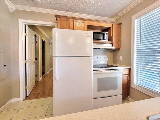 kitchen featuring white appliances, a textured ceiling, crown molding, exhaust hood, and light tile patterned floors