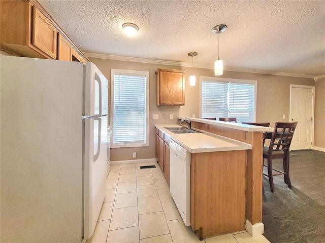 kitchen featuring crown molding, sink, decorative light fixtures, and white appliances