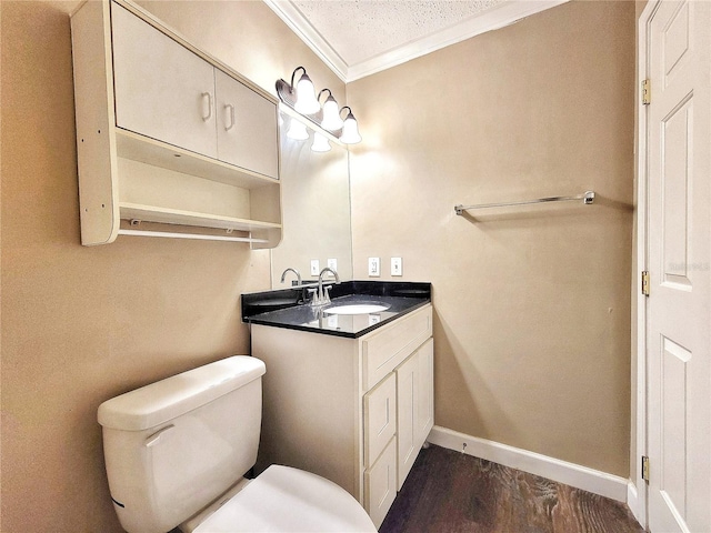 bathroom with vanity, toilet, ornamental molding, a textured ceiling, and wood-type flooring