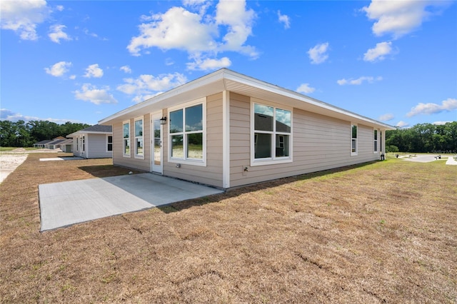 view of side of property with a lawn and a patio area