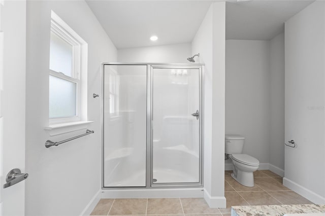 bathroom featuring toilet, a shower with door, and tile patterned flooring