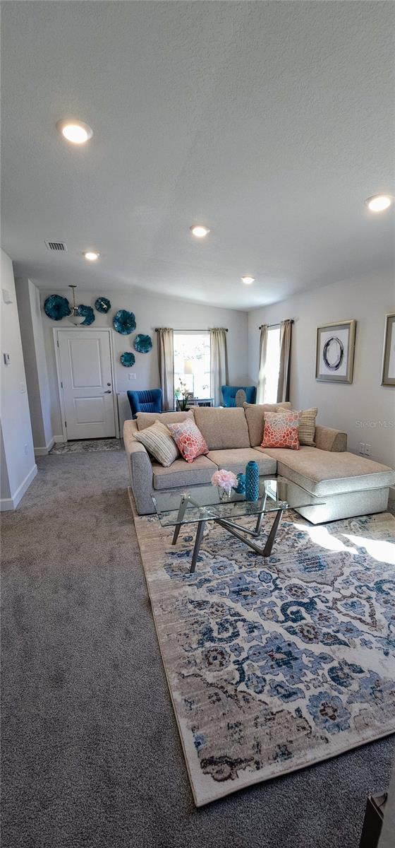 carpeted living room featuring a textured ceiling