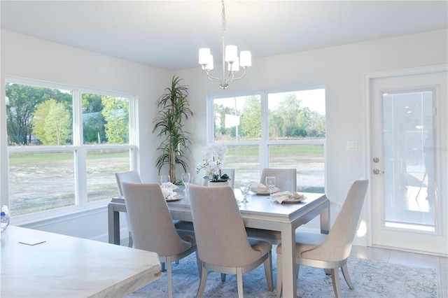 dining area featuring tile patterned flooring, a wealth of natural light, and a chandelier