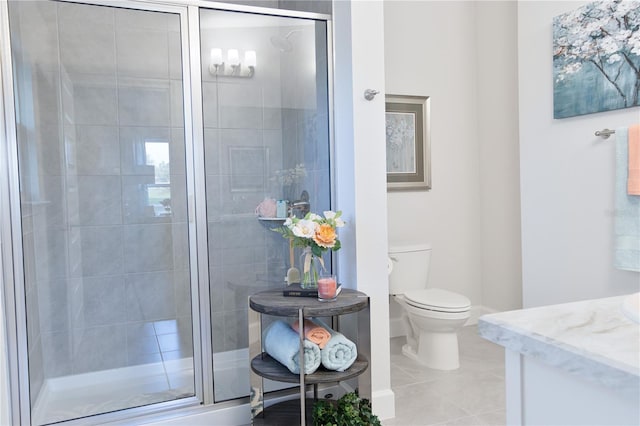 bathroom featuring tile patterned flooring, vanity, toilet, and a shower with door