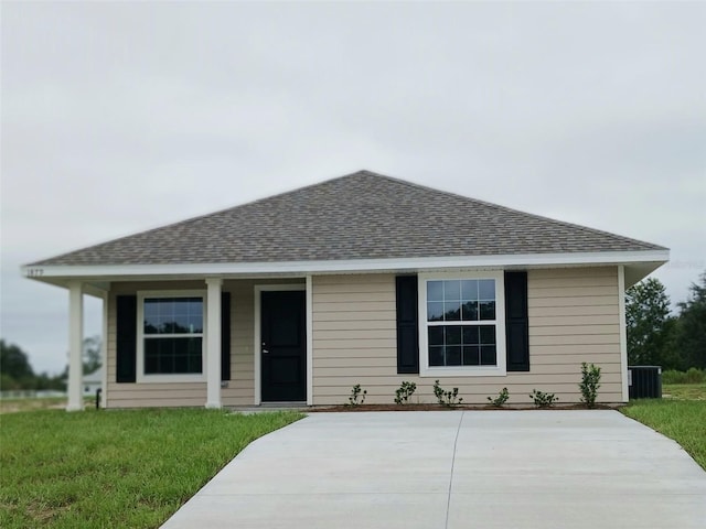 view of front of house featuring central air condition unit and a front lawn