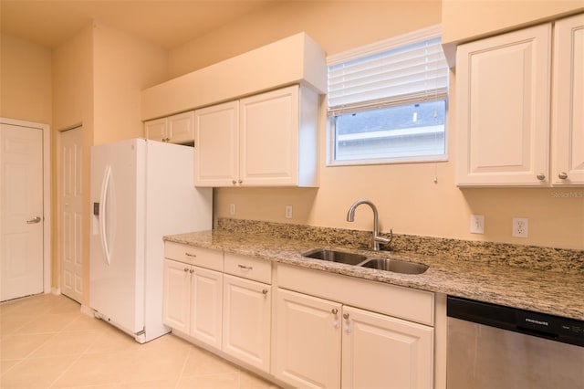 kitchen featuring light stone counters, stainless steel dishwasher, sink, white refrigerator with ice dispenser, and white cabinetry