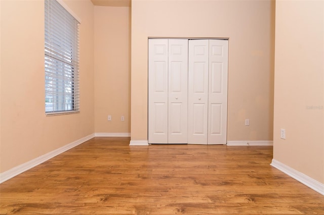 unfurnished bedroom with light hardwood / wood-style flooring and a closet