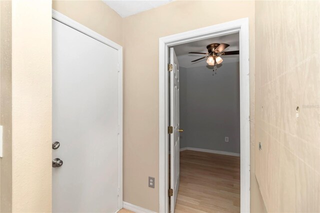 hall with baseboards and light wood-style floors