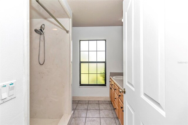 full bathroom with vanity, a shower, and tile patterned flooring