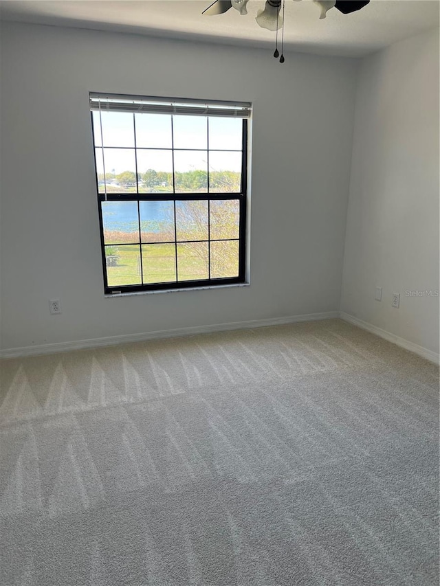 empty room with baseboards, light colored carpet, and a ceiling fan