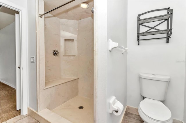 bathroom featuring tile patterned floors, toilet, and a stall shower