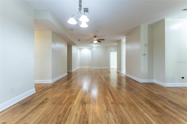 spare room with hardwood / wood-style floors and ceiling fan with notable chandelier