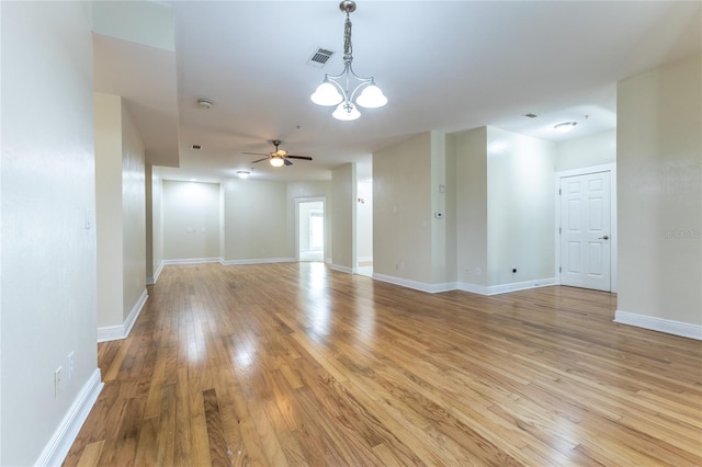 spare room featuring light hardwood / wood-style floors and ceiling fan with notable chandelier