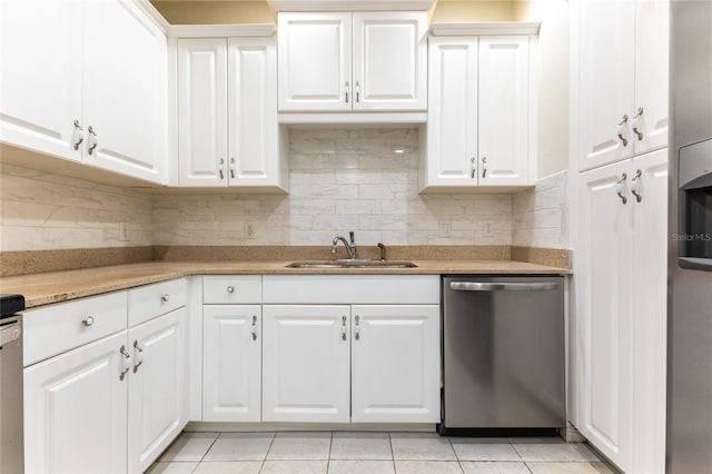 kitchen with white cabinets, sink, stainless steel dishwasher, and light tile patterned flooring