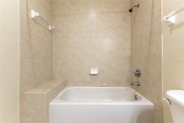 bathroom with tiled shower / bath combo and toilet