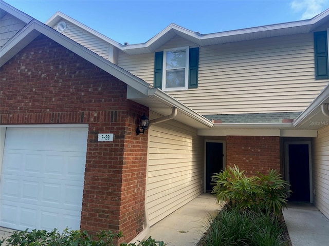 exterior space with an attached garage and brick siding